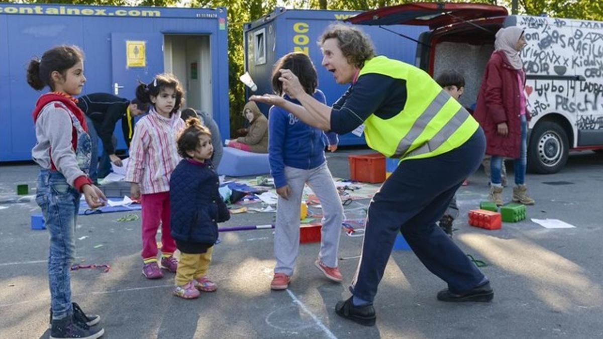 Una voluntaria juega con unos niños en un campo de refugiados en Salzburgo.