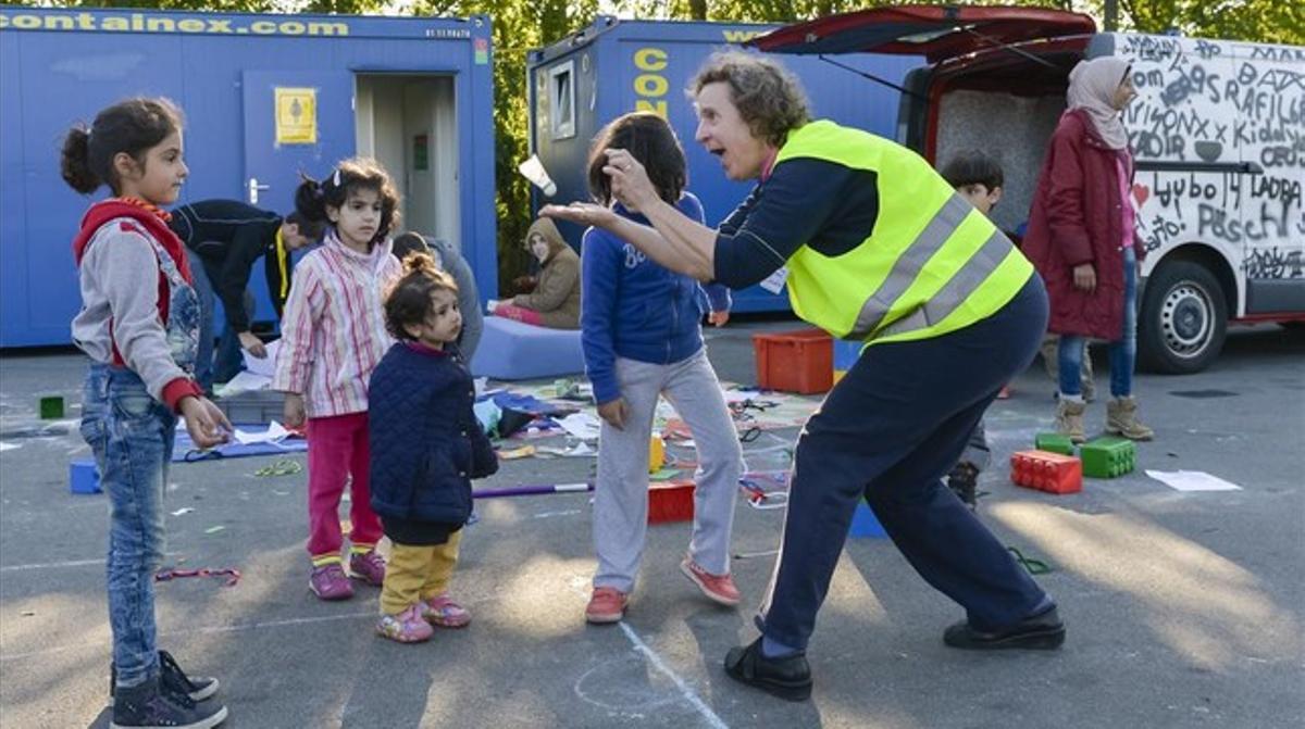 Una voluntària juga amb uns nens en un camp de refugiats a Salzburg.