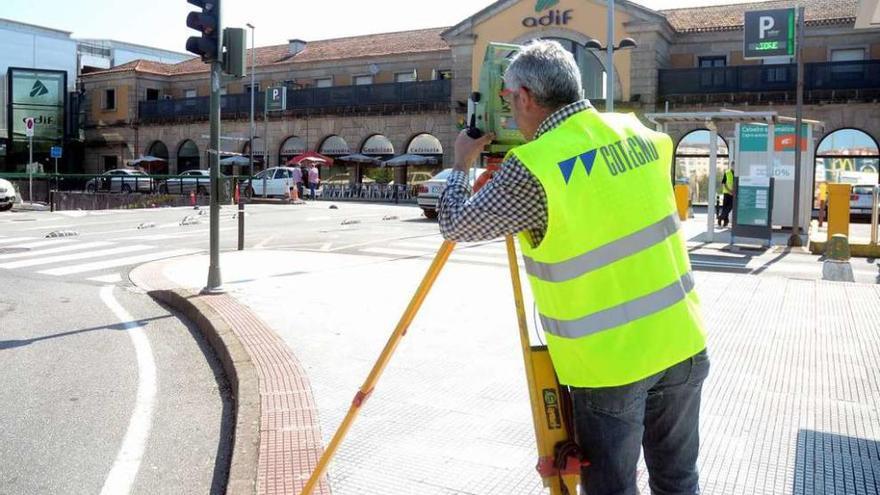 Técnicos realizando ayer las primeras mediciones topográficas ante la estación de tren. // Rafa Vázquez