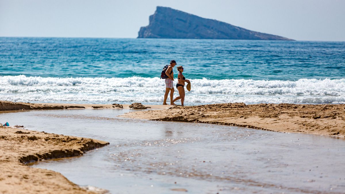 A couple strolls along Benidorm's Levante beach, still in spring weather A couple strolls along Benidorm's Levante beach, still in spring weather