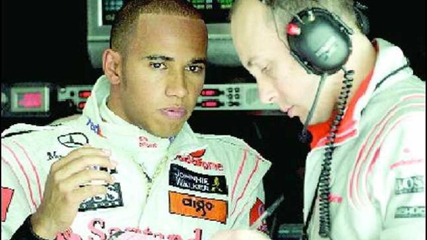 Hamilton cambia impresiones en el box de McLaren con su ingeniero de carrera, Phil Prew.
