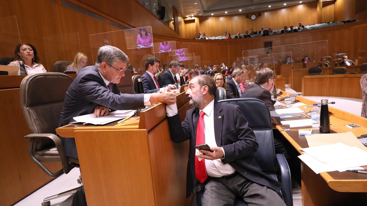 Javier Lambán saluda al portavoz del PSOE, Vicente Guillén, en el transcurso de la segunda jornada del debate del estado de la comunidad
