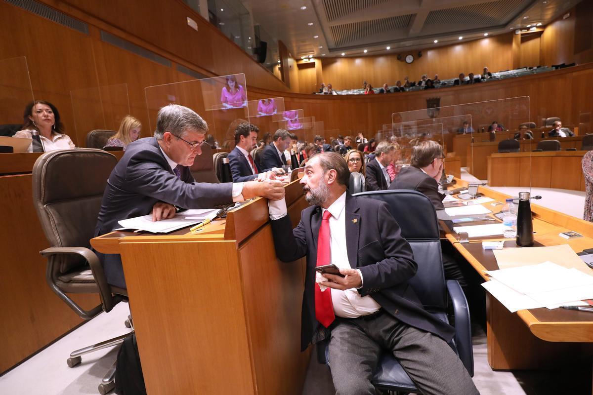 Javier Lambán saluda al portavoz del PSOE, Vicente Guillén, en el transcurso de la segunda jornada del debate del estado de la comunidad
