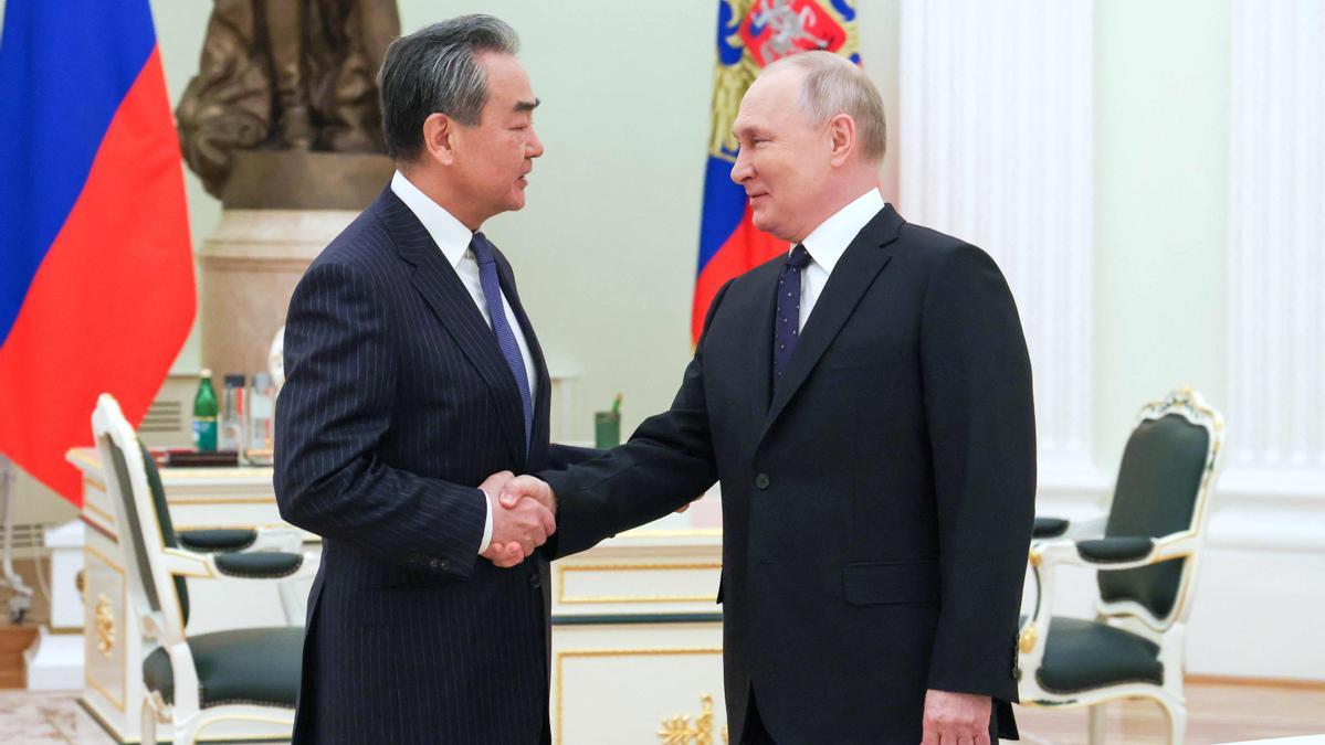 El presidente ruso, Vladímir Putin, estrecha la mano del jefe de la diplomacia china, Wang Yi, este miércoles en el Kremlin.