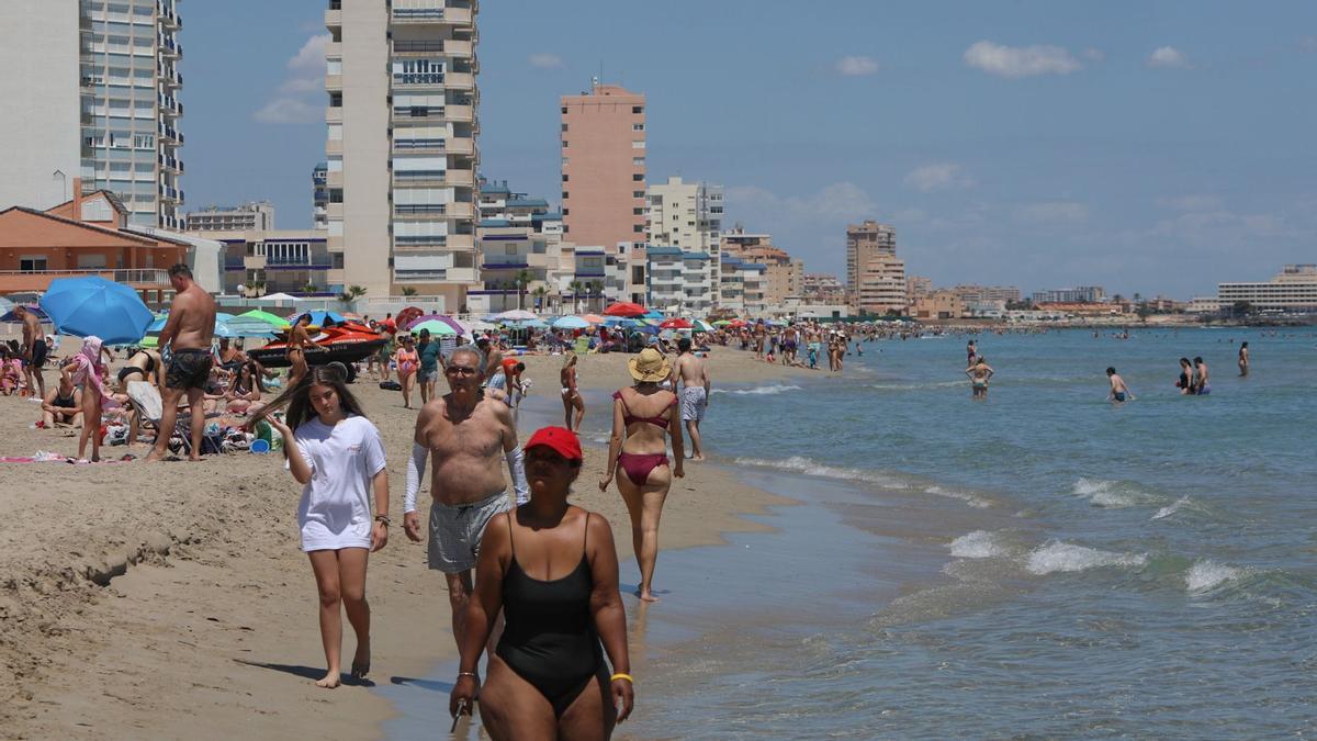 Bañistas caminan por la orilla de una playa en Cartagena.