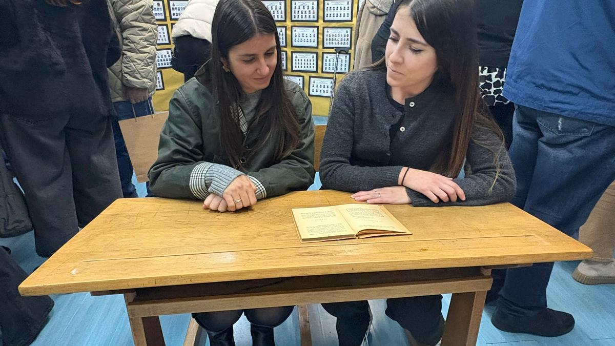 Eva Fernández y Paula Salvador, profesoras del Aniceto Sela, en un antiguo pupitre de madera