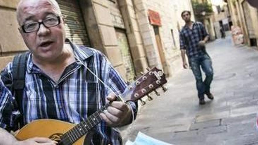 Quico Palomar en plena actuació al carrer, i la carpeta oberta al costat