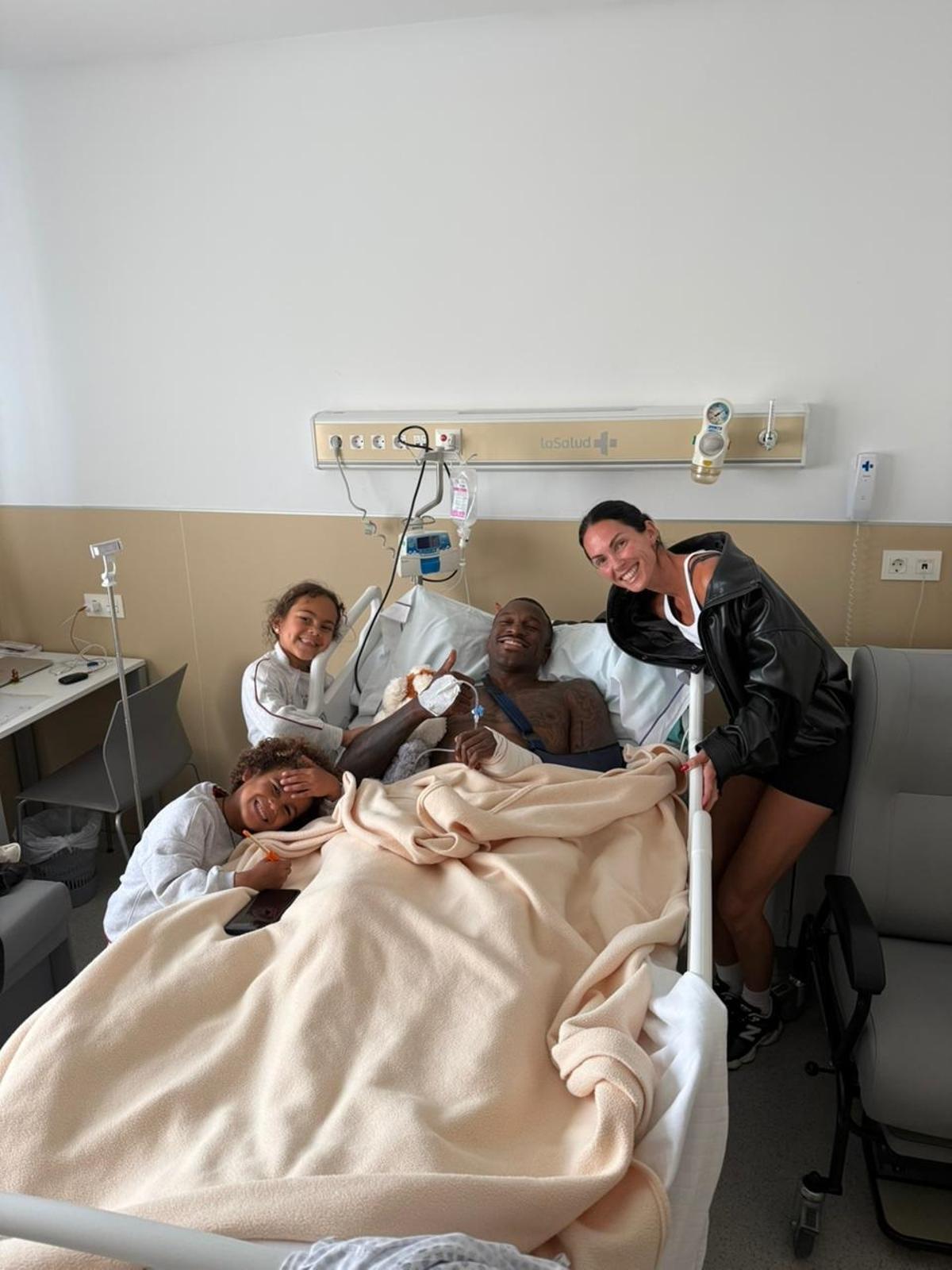 Dylan Ennis, sonriente junto a sus hijos y su mujer en el hospital de Valencia donde ayer fue operado de la muñeca izquierda