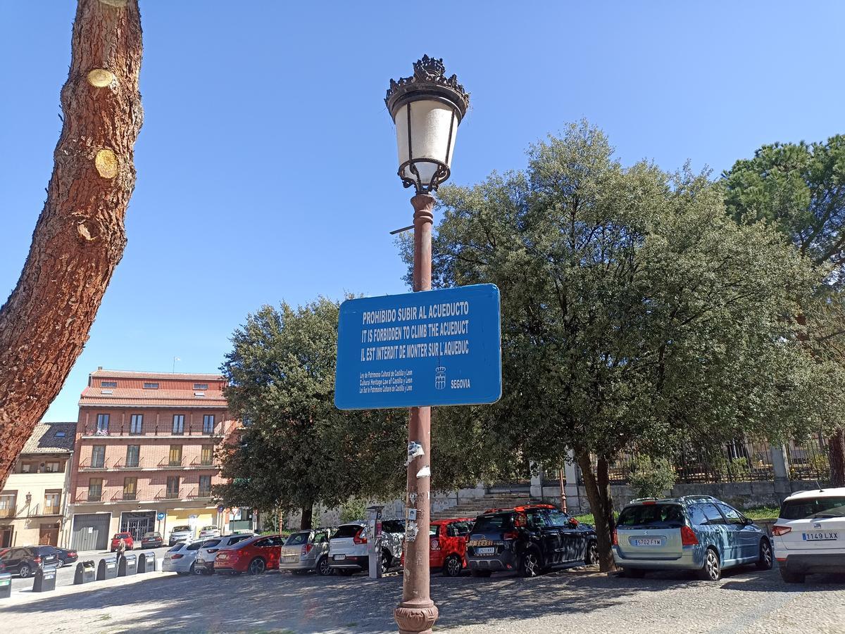 Dos carteles en la calle Almira de Segovia alertan de que está prohibido subirse al acueducto. 