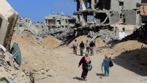 Los palestinos inspeccionan las casas y carreteras en gran parte destruidas después de que el ejército israelí se retirara de la ciudad de Abasan.