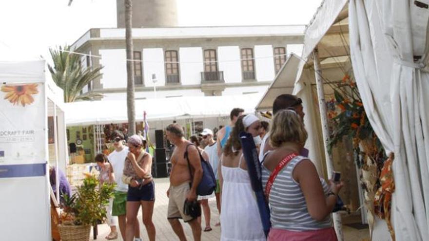 Imagen de los primeros compradores y turistas que visitaron ayer por la tarde la Feria de Artesanía en el Faro de Maspalomas. | luis del rosario