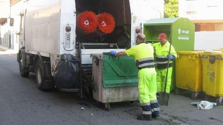 Los operarios del servicio colocan un contenedor para su lavado.