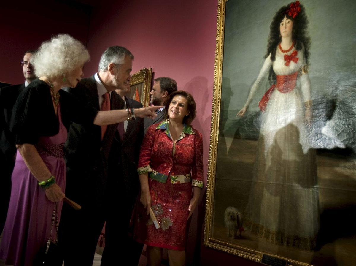 Cayetana Fitz-James Stuart y Silva, duquesa de Alba, rodeada de las autoridades de la Junta de Andalucía en 2009, frente al cuadro de Goya, 'La duquesa de Alba de blanco' pintado en 1795 y el favorito de su colección familiar.