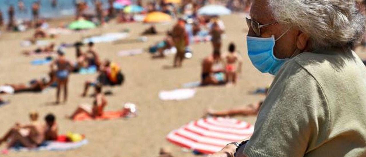 Una señora con mascarilla se asoma a la playa de Las Canteras. | | LP / DLP