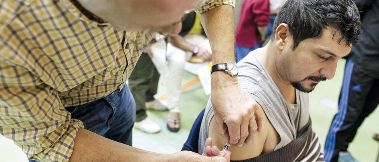 Un adulto durante la administración de una vacuna. // efe