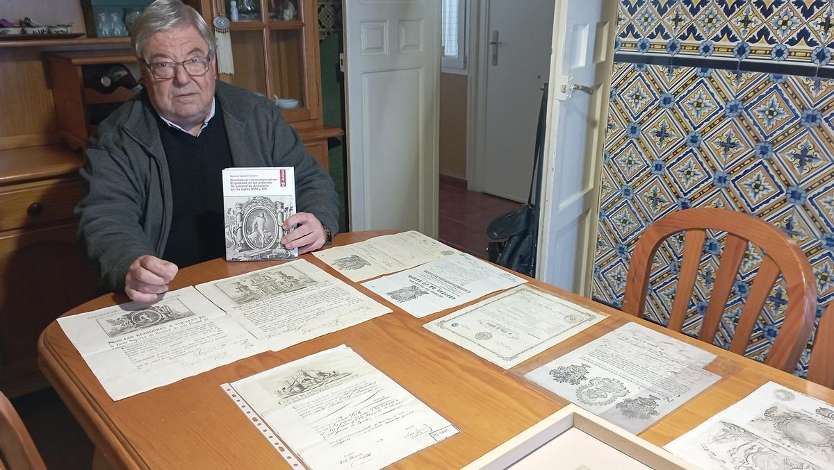 Federico Castellón, en su casa de Málaga, con su nuevo libro sobre las patentes de sanidad andaluzas y varias patentes de su colección.
