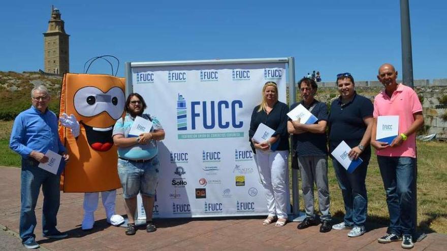 Directivos de la Federación Unión de Comercios Coruñesa posan, ayer, con la nueva imagen y su mascota.