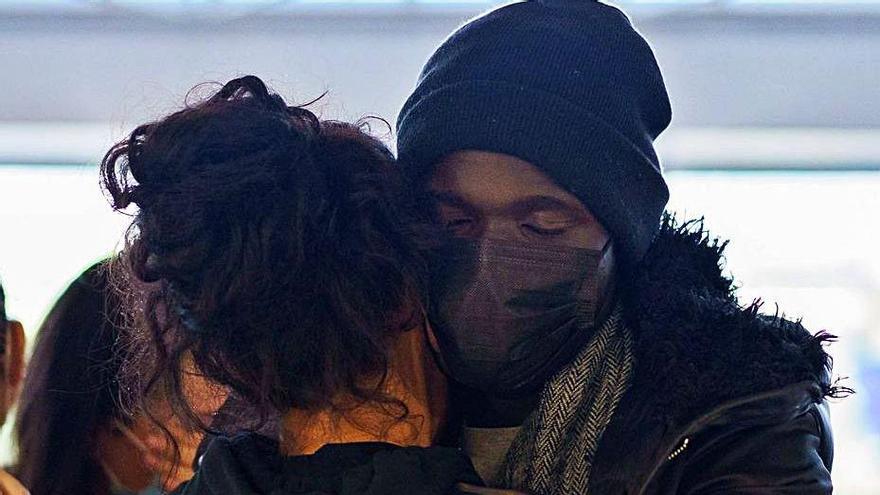 Ibrahima se abraza a una de las voluntarias de la ONG en el aeropuerto.