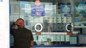 Una persona se dispone a adquirir un boleto en una Administración de Loterías.