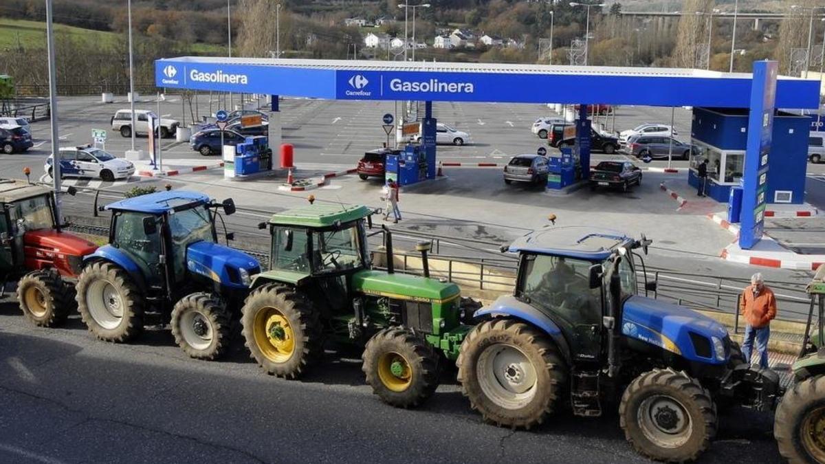 Protesta de tractors davant una benzinera.