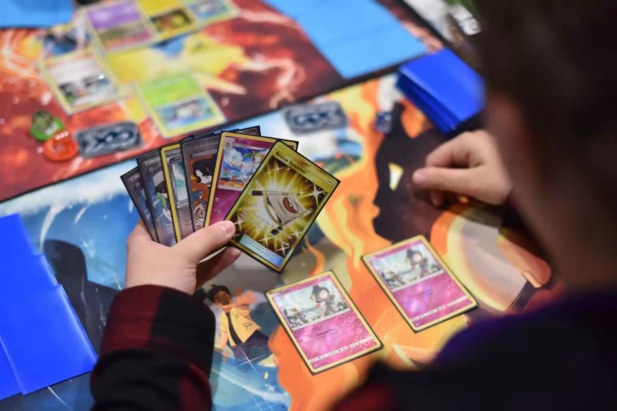 Unos jóvenes juegas a las cartas de Pokémon.
