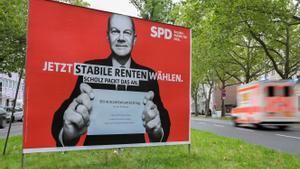 Un coche pasa frente a un cartel electoral del candidato socialdemócrata, Olaf Scholz, que anima a los votantes a emitir el voto por correo.