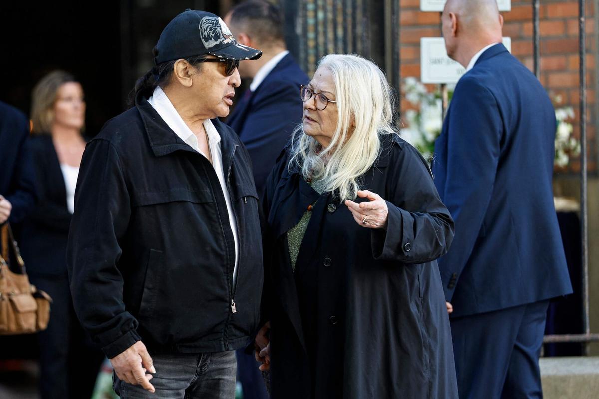 French actress Josiane Balasko (R) speaks with her husband US actor George Aguilar as they leave after the funeral ceremony of French actress Nadia Fares at the Saint-Jean de Montmartre church in Paris on April 24, 2026. Nadia Fares died on April 17, 2026, aged 57, after being found unconscious in a swimming pool in Paris and several days in a coma. (Photo by SIMON WOHLFAHRT / AFP)