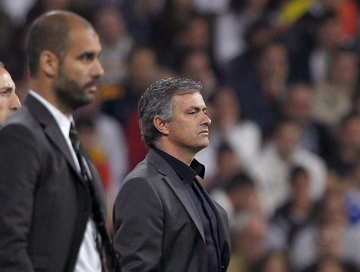 Los entrenadores del Real Madrid y del FC Barcelona, el portugués José Mourinho (d) y Pep Guardiola, respectivamente, durante el partido correspondiente a la trigésima segunda jornada del Campeonato Nacional de Liga de Primera División que enfrenta esta noche a ambos equipos en el estadio Santiago Bernabéu.