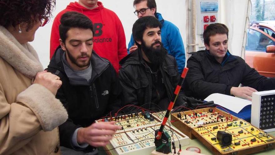 Arriba, Alejandro Castro, Carlos Álvarez y Juan Fernández muestran una maqueta de un paso a nivel. Sobre estas líneas, Joyce Steijger y Abdelaziz Haloumi hacen una prueba de gases a un automóvil en la carpa de Electromecánica.