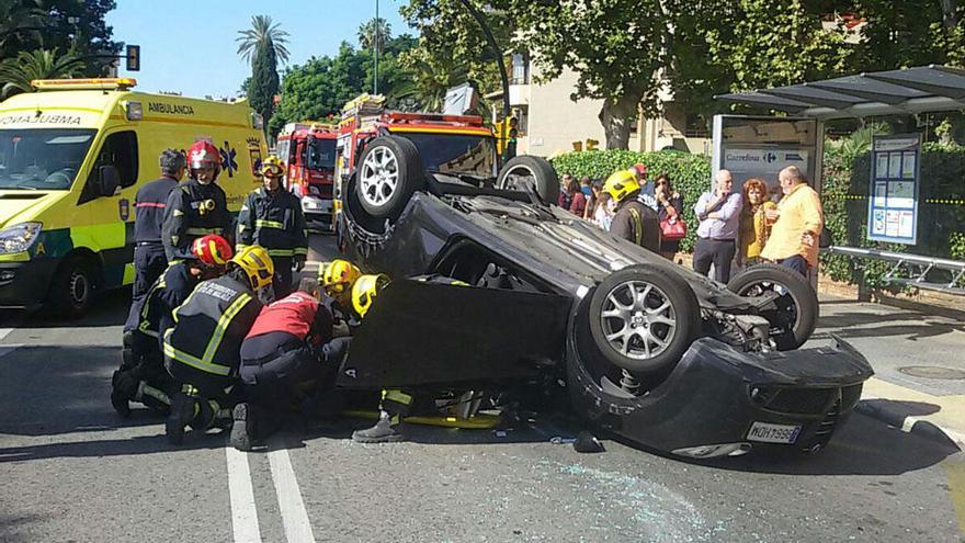 Los bomberos tratan de rescatar a la conductora accidentada.