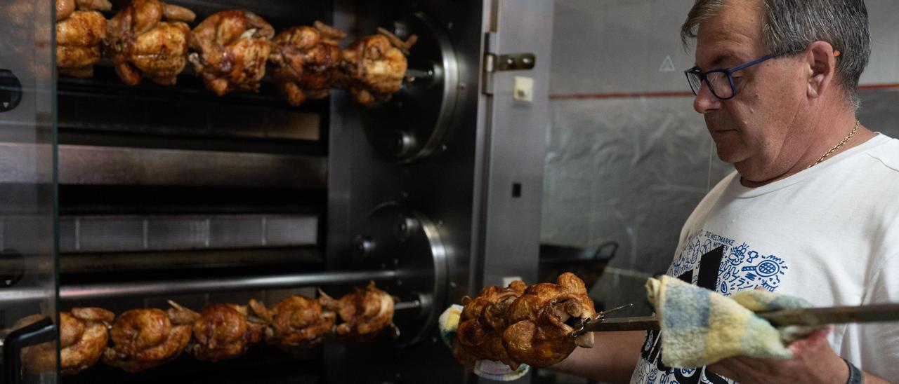 Un cocinero soporta el calor del horno mientras trabaja en la pollería.