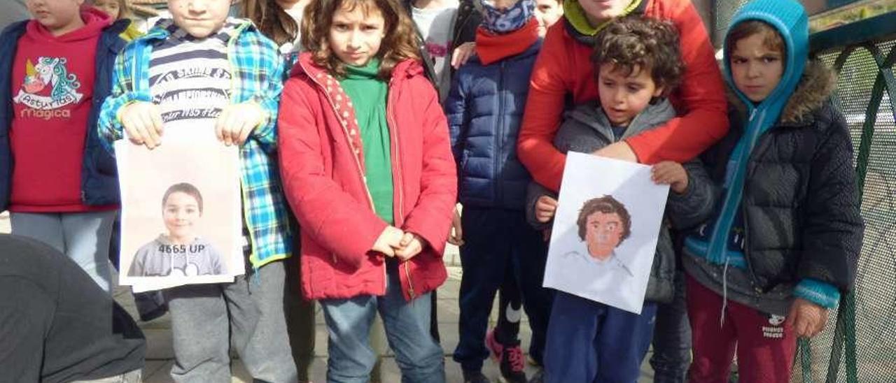 Ian Sánchez y Teo Llaneza muestran sus foto y dibujo rodeados de sus compañeros de colegio.