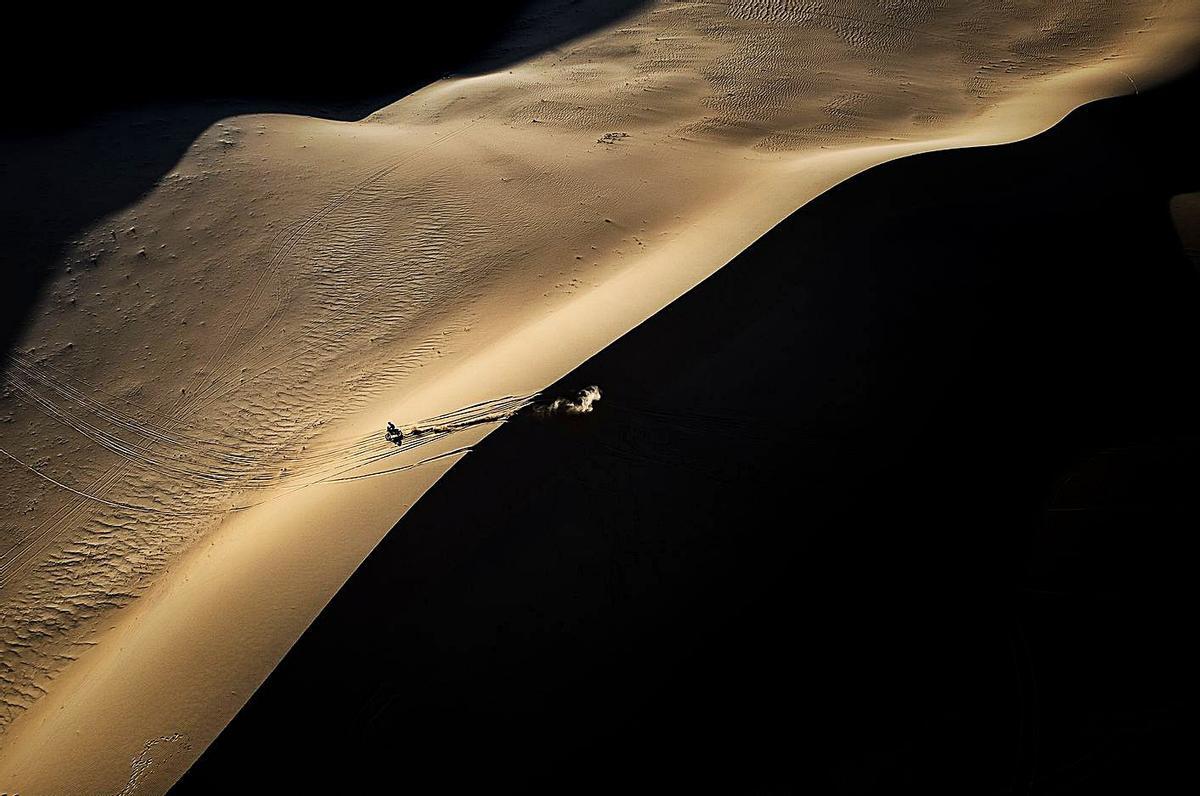La fotografía ganadora del premio “Emilie Poucan”: un motorista en una duna durante la prueba de este año. En el recuadro, el autor de la instantánea. | Charly López