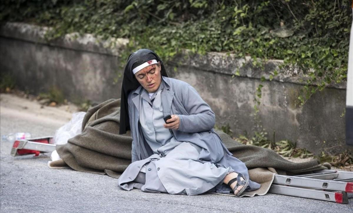 Una monja mira su móvil tras el terremoto.