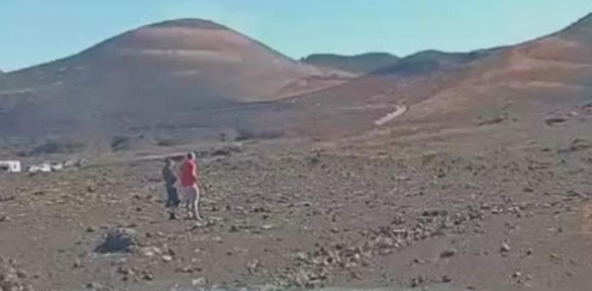 Turistas caminando fuera de la carretera en Timanfaya.