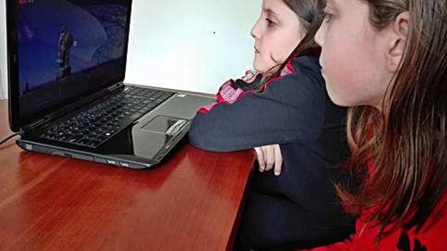 Dos niñas, siguiendo la visita virtual a la Torre de Hércules.