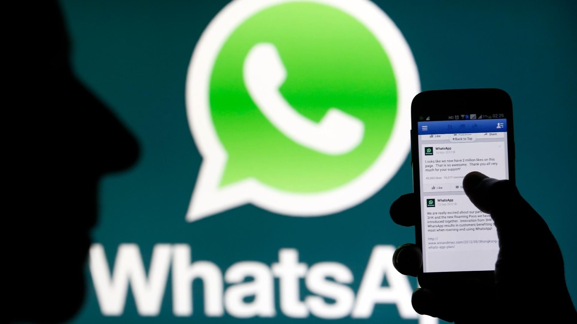 Una persona muestra mensajes de Whatsapp en un teléfono móvil.