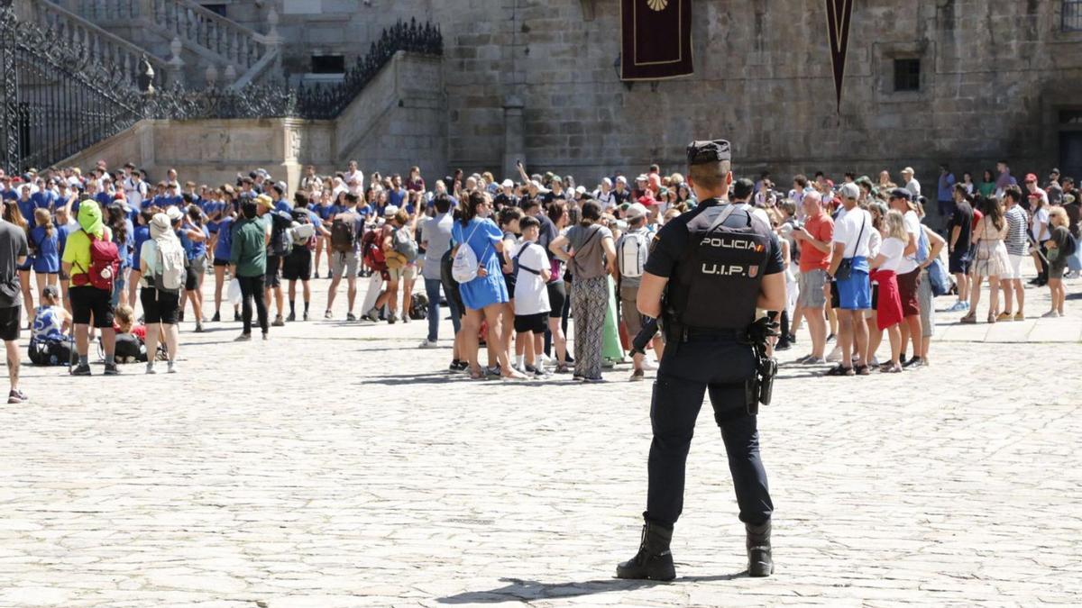 Un agente policial vigilando el flujo de peregrinos y turistas en la plaza del Obradoiro