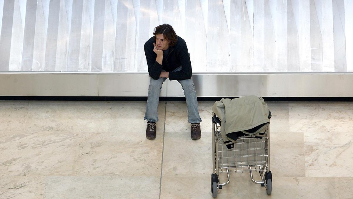 Un pasajero espera en la cinta de equipajes a que salga su maleta en elaeropuerto de Barajas.