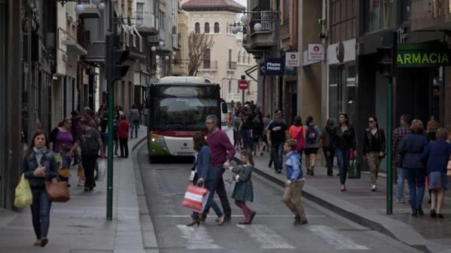 Circulación de peatones y un autobús por la calle Corredora, una de las vías más importantes de Elche.