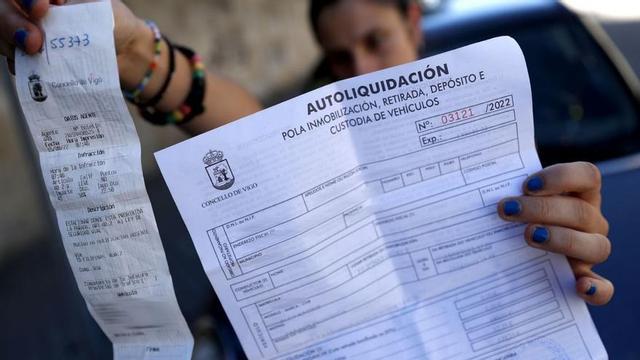 Una vecina con la multa y la liquidación que tuvo que pagar para sacar su coche del depósito.   | // JOSÉ LORES