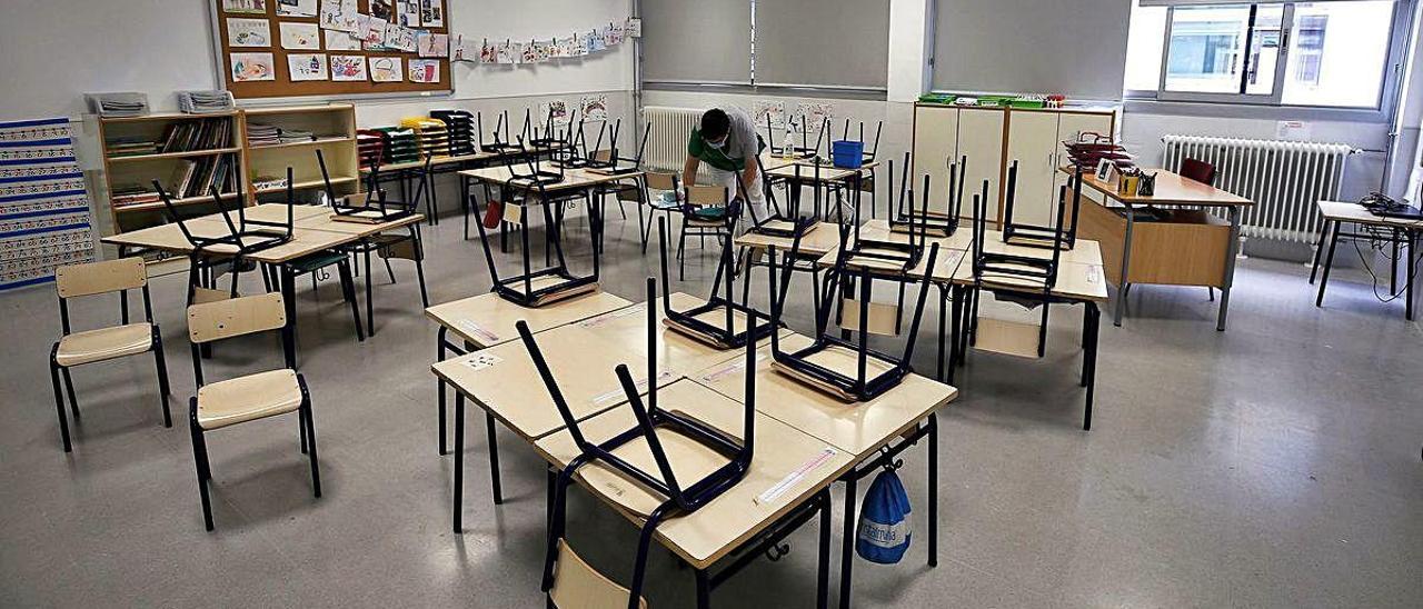 Desinfección de sillas y pupitres en una clase de Infantil de València, en mayo.