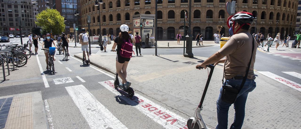 Dos usuarios de patinetes circulan por el carril bici de la calle Colón.