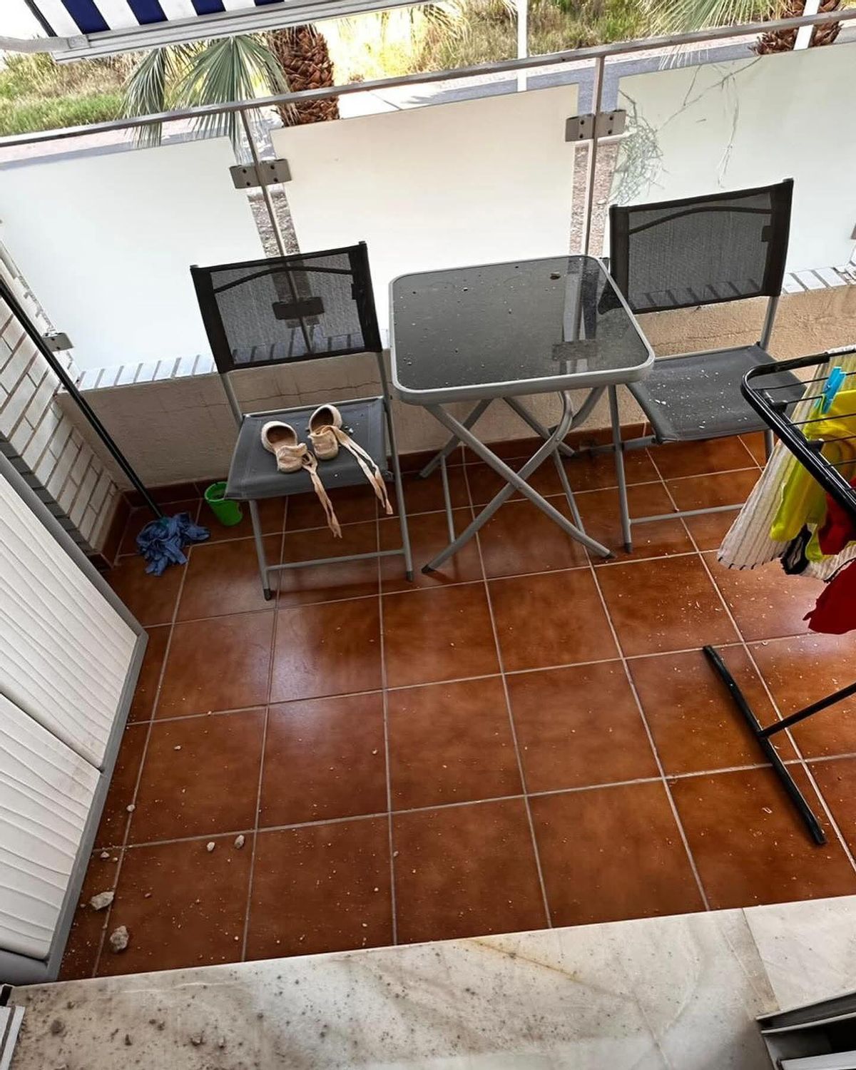 Imagen de la terraza de la vivienda con el cristal del balcón roto.