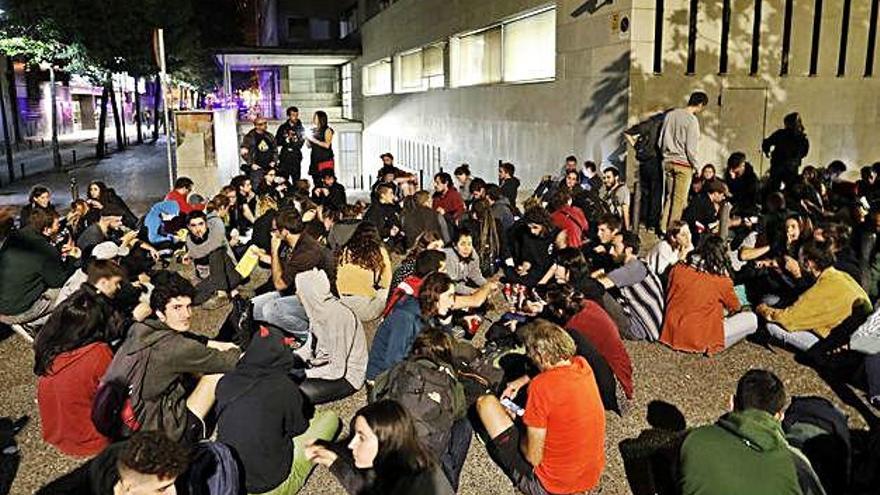 Joves asseguts a terra bloquejant la sortida de l&#039;aparcament dels Jutjats de Girona, ahir a la nit.