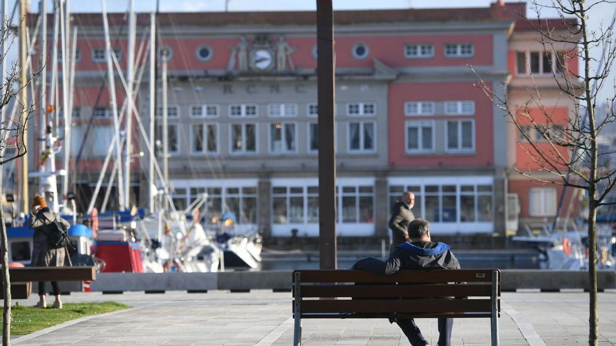 Una persona descansa en un banco de la Marina un día soleado de invierno.