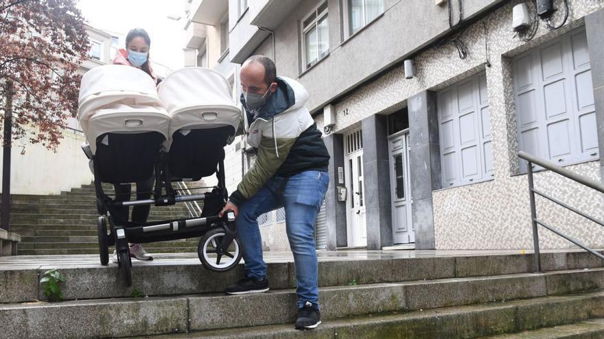 Una pareja baja un carrito por las escaleras de Pintor Villar Chao.   | // CARLOS PARDELLAS