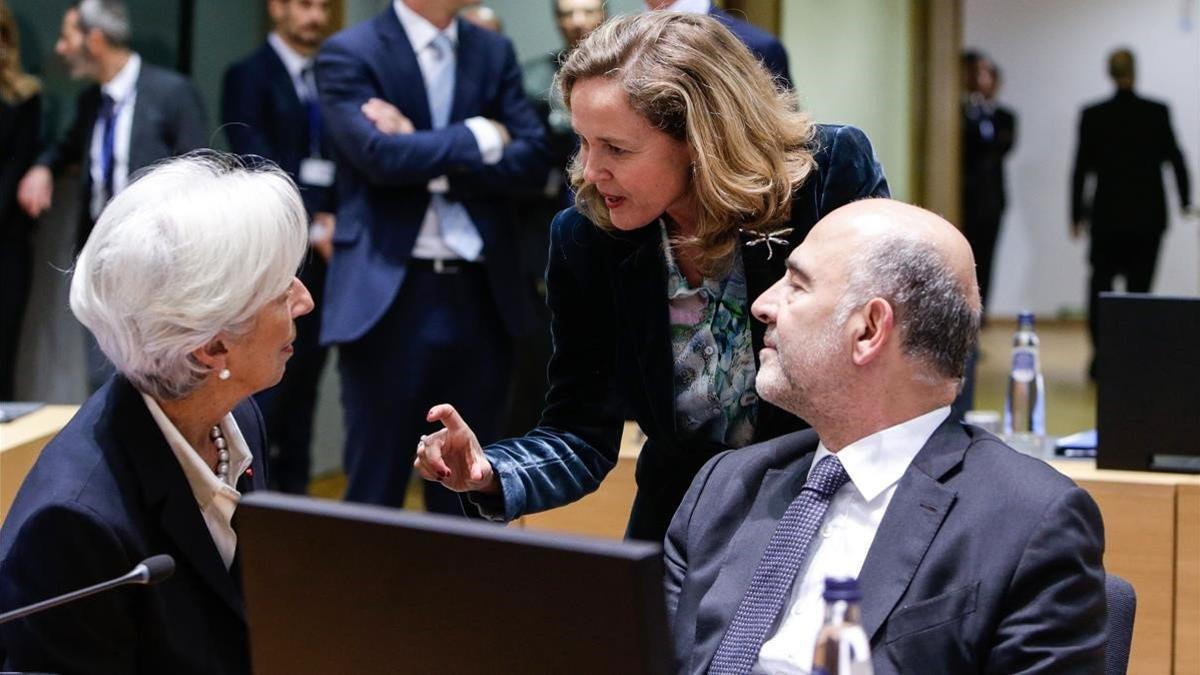 La ministra Nadia Calviño (de pie) conversa con la presidenta del BCE, Christine Lagarde, y el comisario europeo de Asuntos Económicos, Pierre Moscovici, en Bruselas