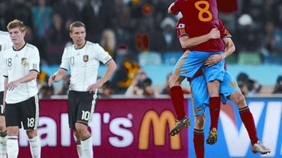 Xabi y Busquets se abrazan tras el gol ante la decepción de los jugadores alemanes.