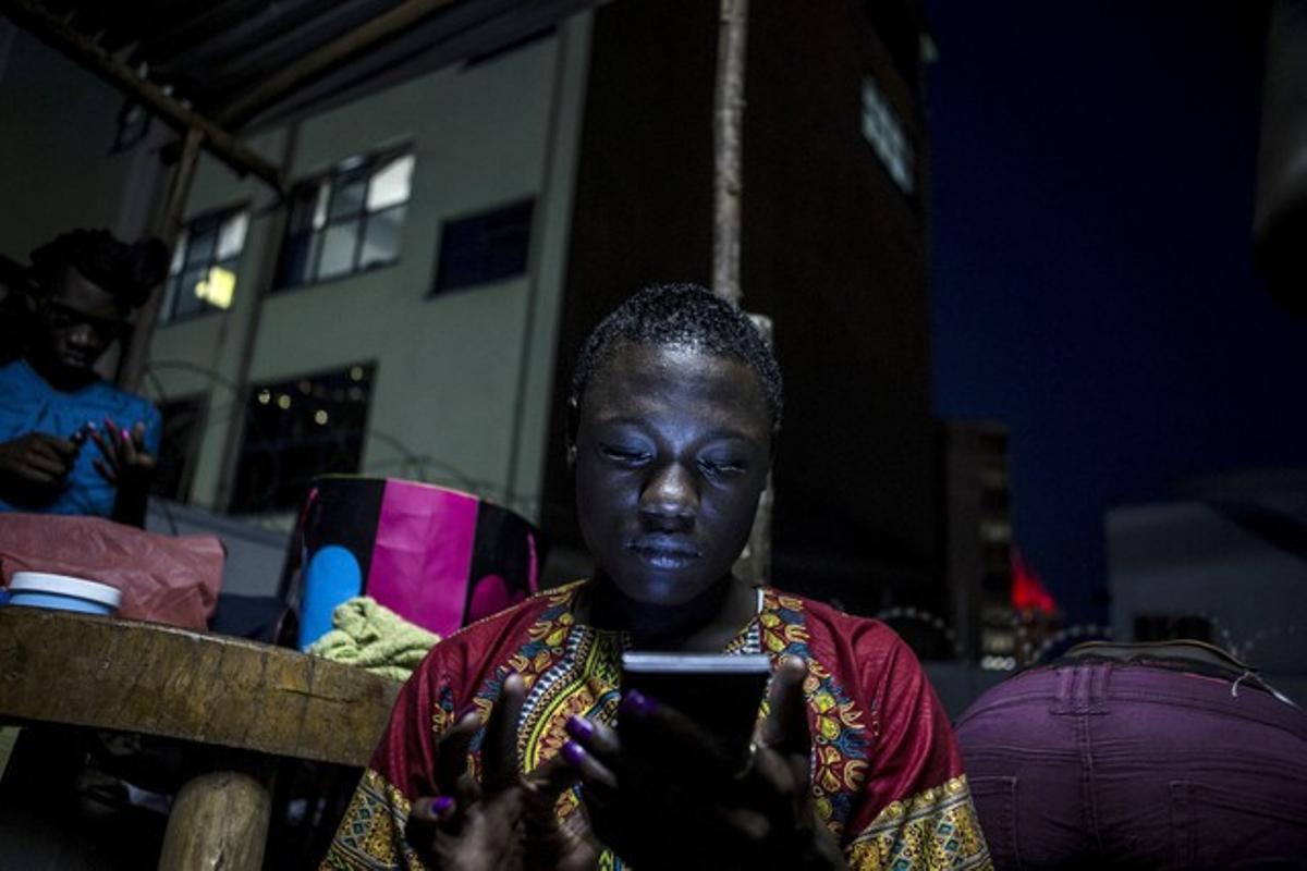 Una dona mira el seu telèfon a la capital d’Uganda, Kampala.